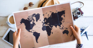 world map with travel supplies around it