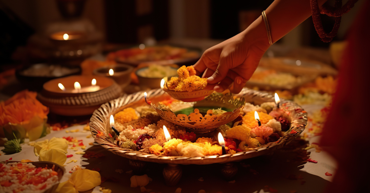 Traditional puja prayer ritual, with bowl of flowers and candles. From Adobe Stock.