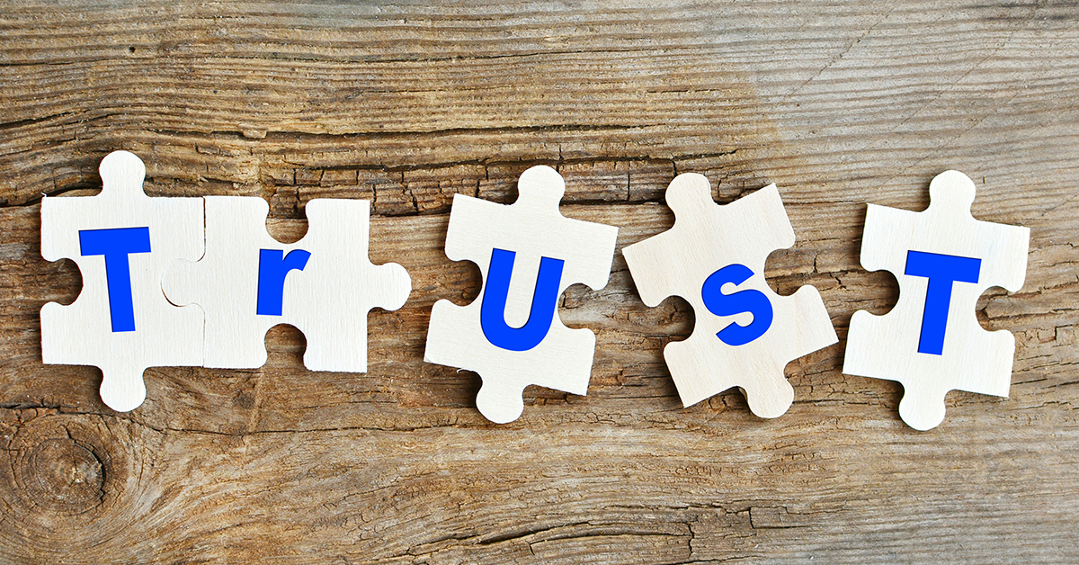 Trust concept. Puzzles with letters on a wooden background. Concept of building trust.