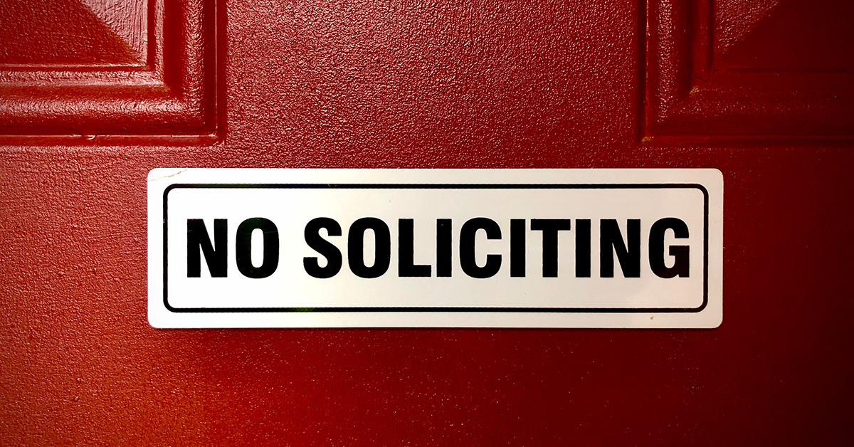 No soliciting sign on a red door