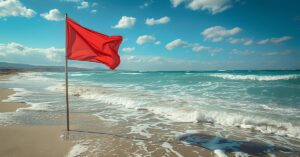 A red flag at sea warns of large, dangerous waves