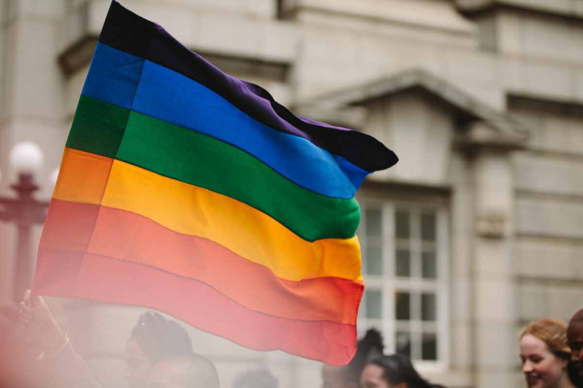 Gay rainbow flag seen during pride parade in the city. Parade goers participate in gay pride march.