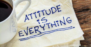 attitude is everything - motivational slogan on a napkin with a cup of coffee