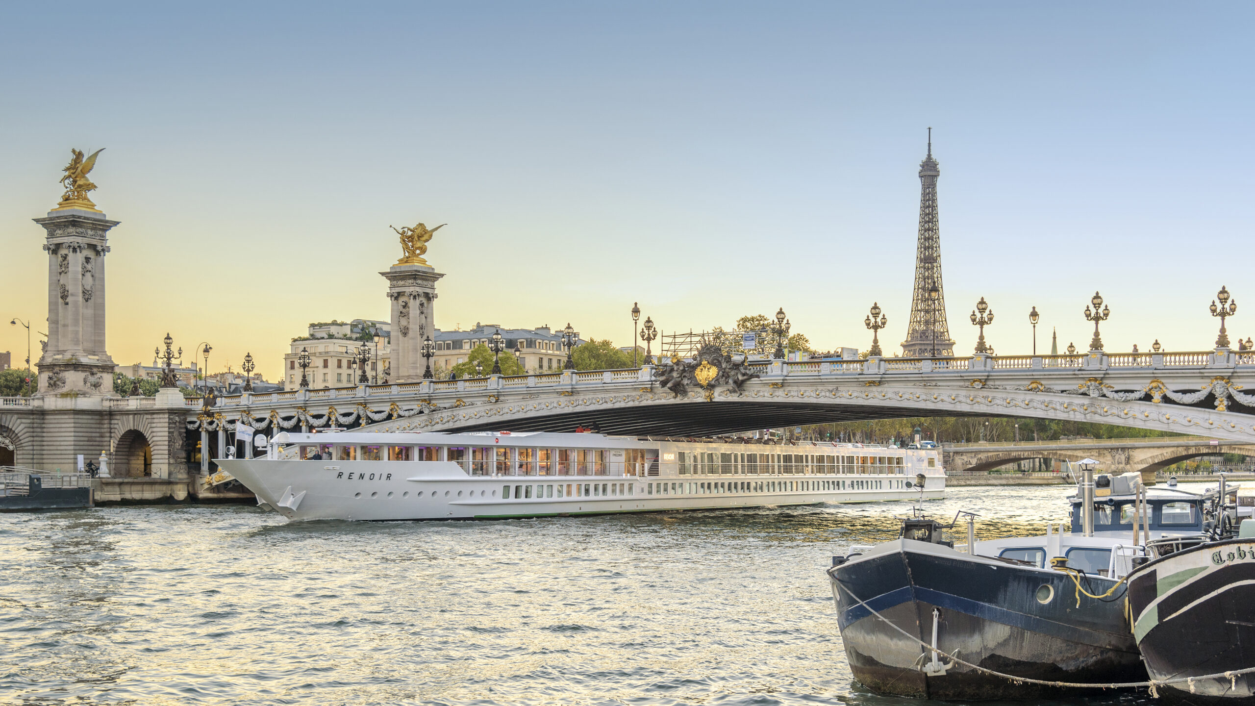 Paris with sunset and MS Renoir river cruise ship. 