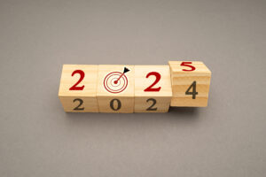 Business planning and countdown to 2025. Flipping 2024 to 2025 on wooden cubes on a gray background